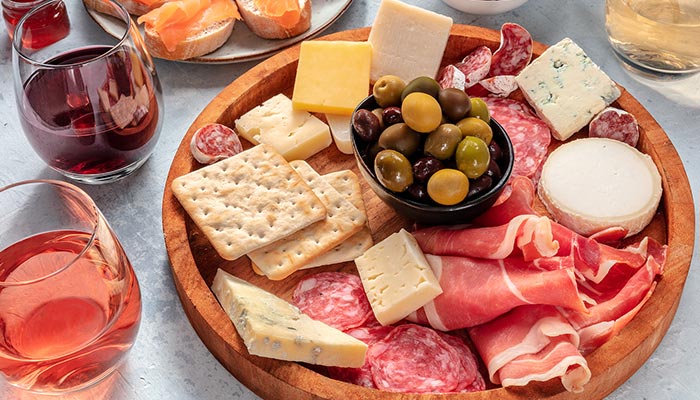 A wooden platter with cured meats and cheeses at Spiros All Day Diner, perfect for Lunch & Dinner.
