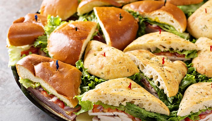 Assorted sandwich halves with lettuce and deli meats, perfect for Lunch & Dinner at the restaurant.