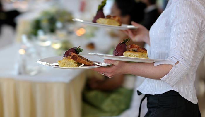 A restaurant server delivers gourmet lunch & dinner plates at a formal event in Tooele, Utah.