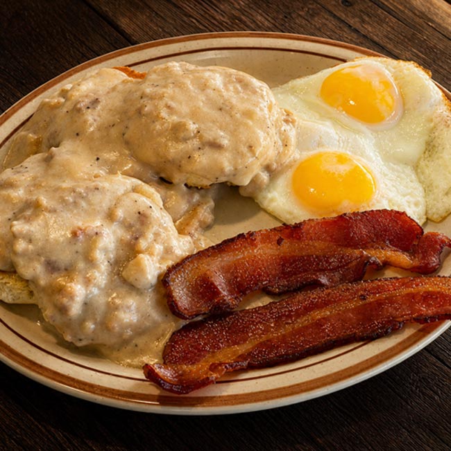 Biscuits with gravy, sunny-side up eggs, and crispy bacon at a top breakfast restaurant Tooele UT.