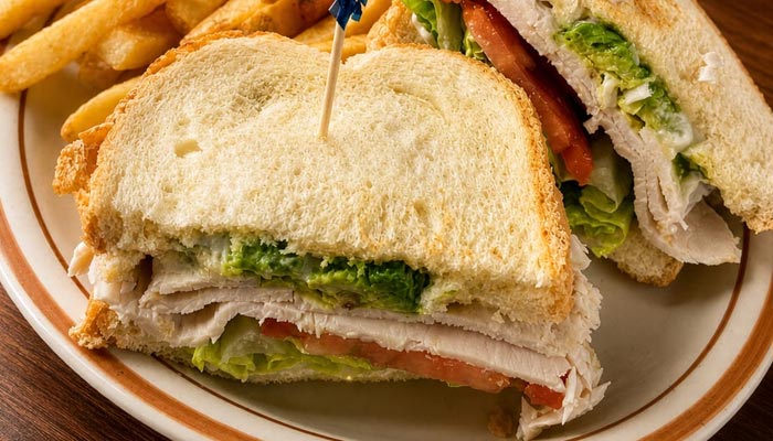 Turkey sandwich with lettuce and tomato, served with fries at our Breakfast Restaurant Tooele UT.