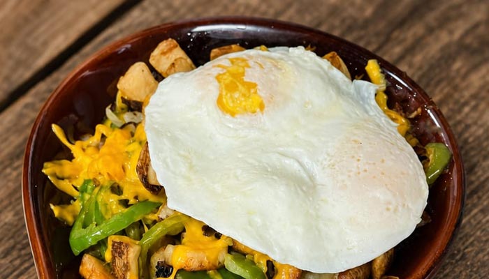 A fried egg crowns potatoes, peppers, and cheddar—your Breakfast Menu Tooele UT favorite.